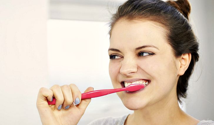 Девушка чистит зубы